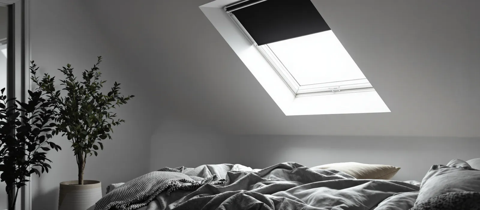 Slaapkamer met verduisterend rolgordijn op dakraam
